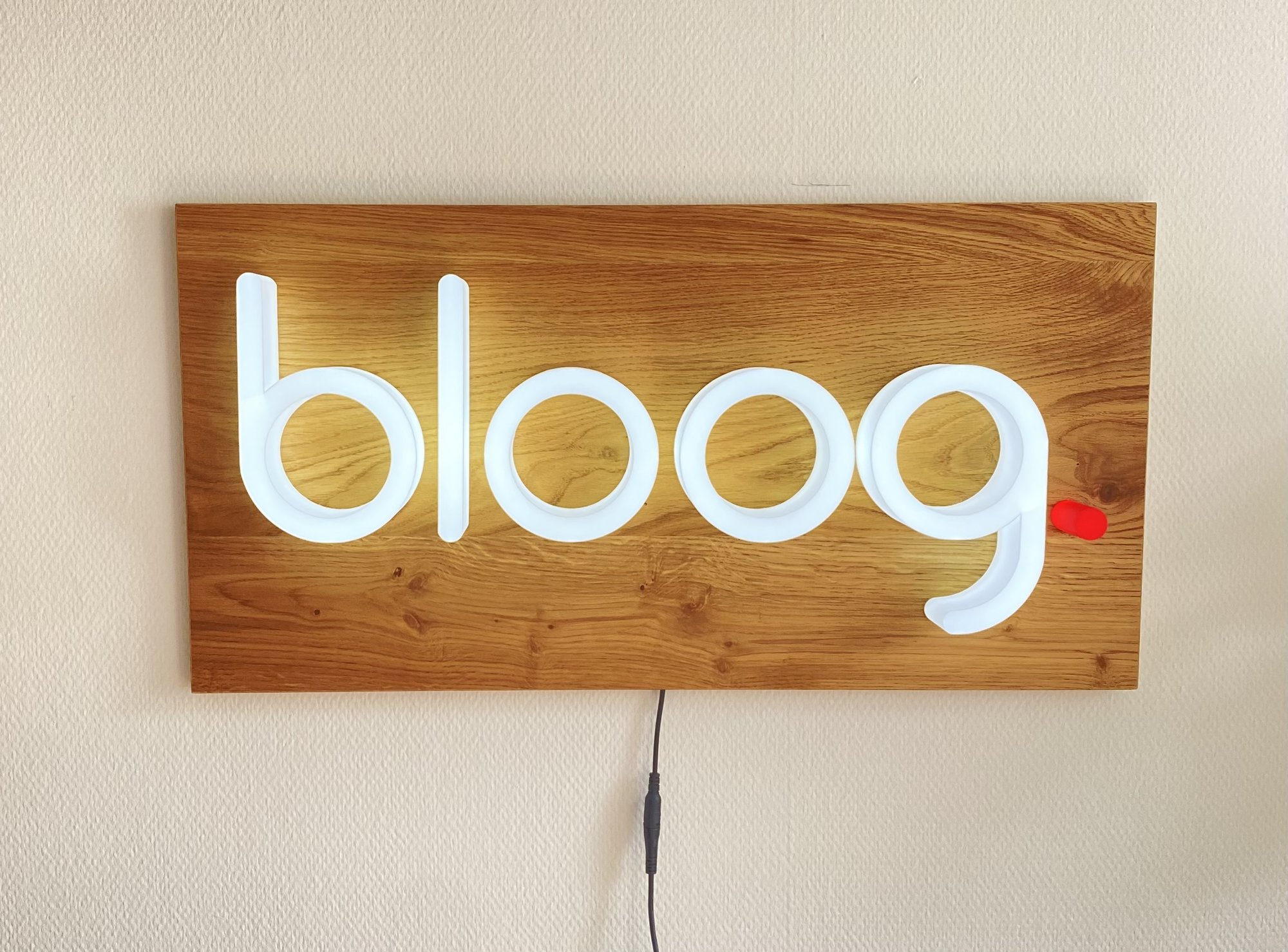 Bloog — beleuchteter Schriftzug auf Holzplatte, wandmontiert