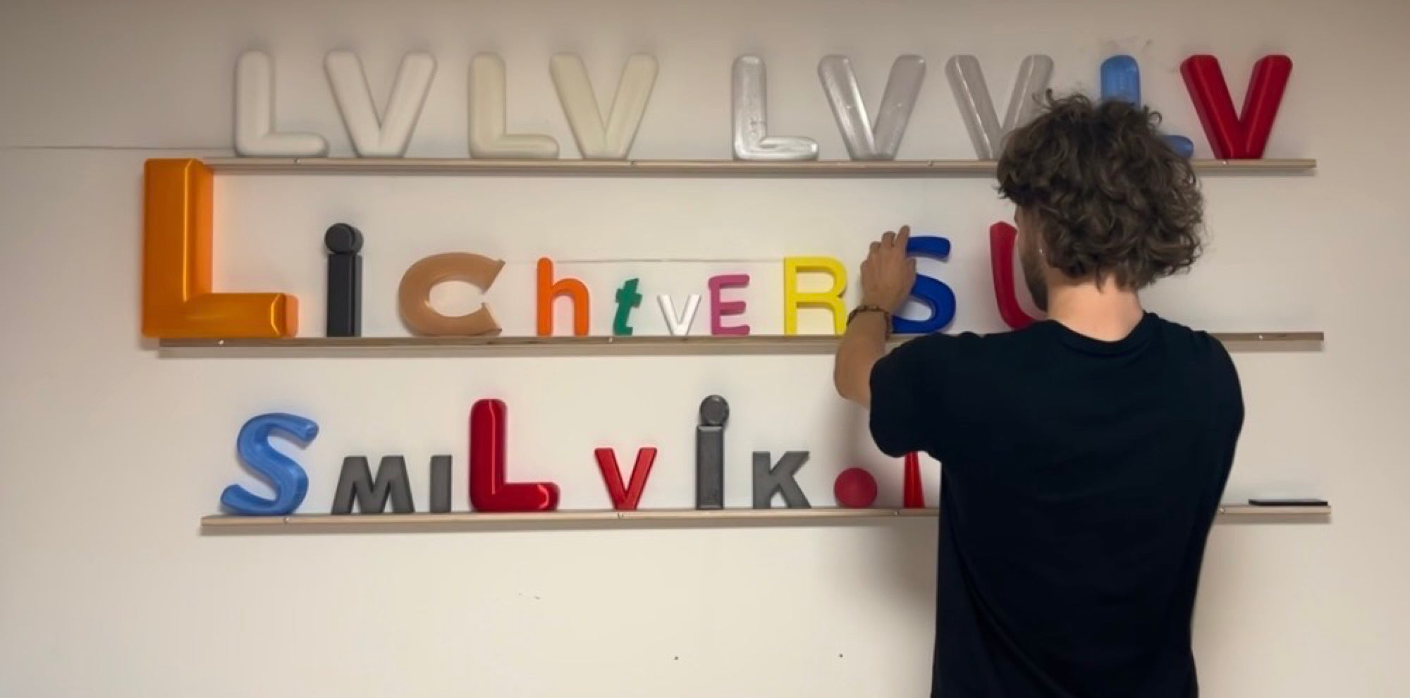 Konsti arrangiert bunte 3D-Buchstaben — Lichtversum Hamburg